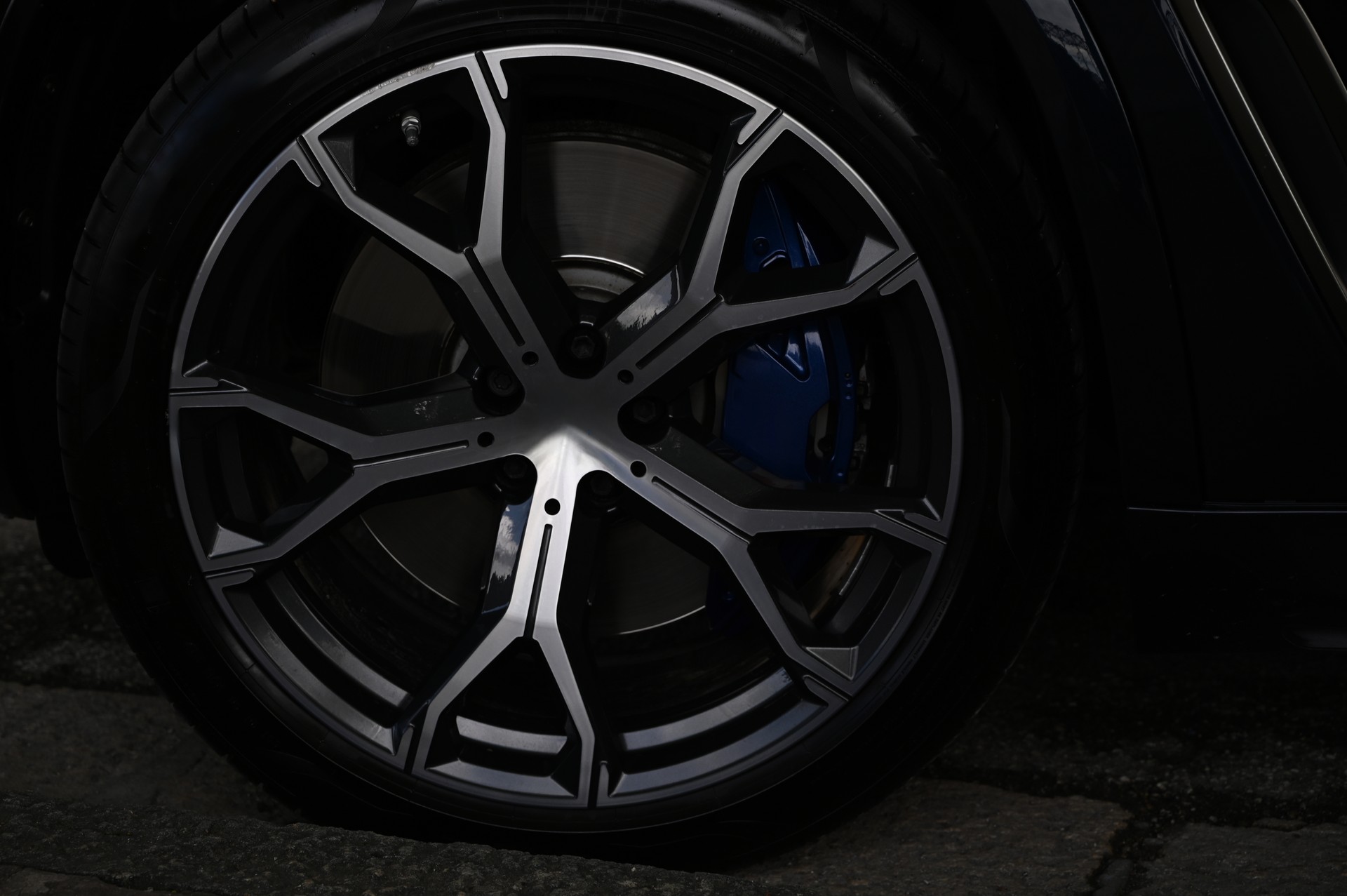 Close up of a silver wheel rim on a street.